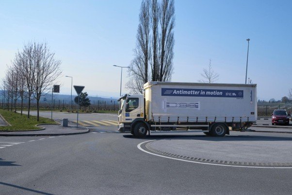 反物質輸送の試験として、CERN敷地内の道路を走行する「Antimatter in motion」と書かれたトラックの様子
